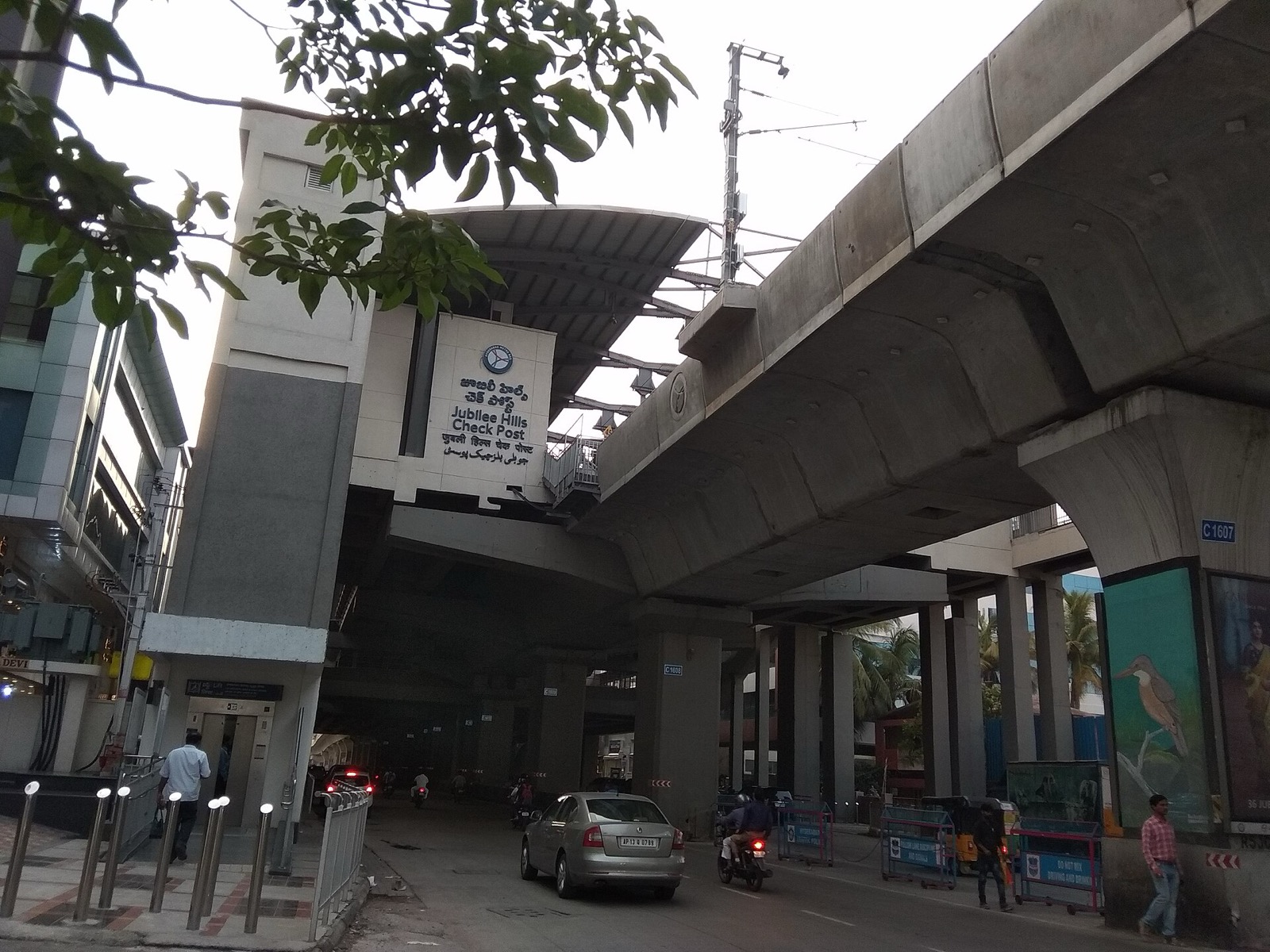 Under the metro viaduct at Jubilee Hills Check Post, with numbered pillars along the road